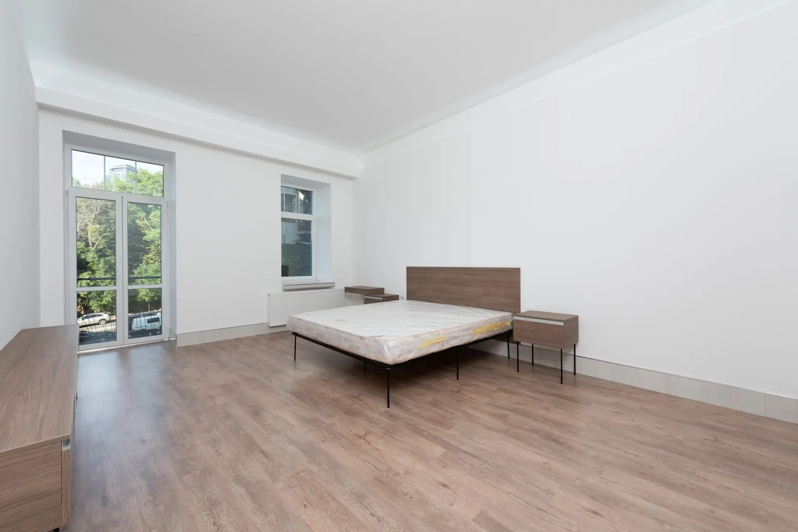 Bright bedroom with light wood-look vinyl planks in straight rows