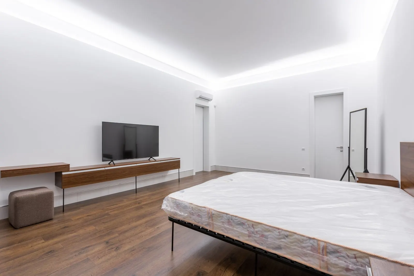 Bedroom with brown wood-look laminate floor laid in straight rows