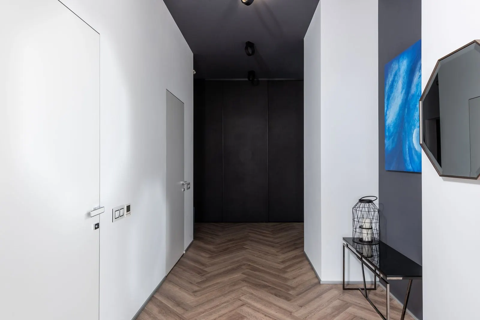Narrow hallway with a light oak herringbone floor