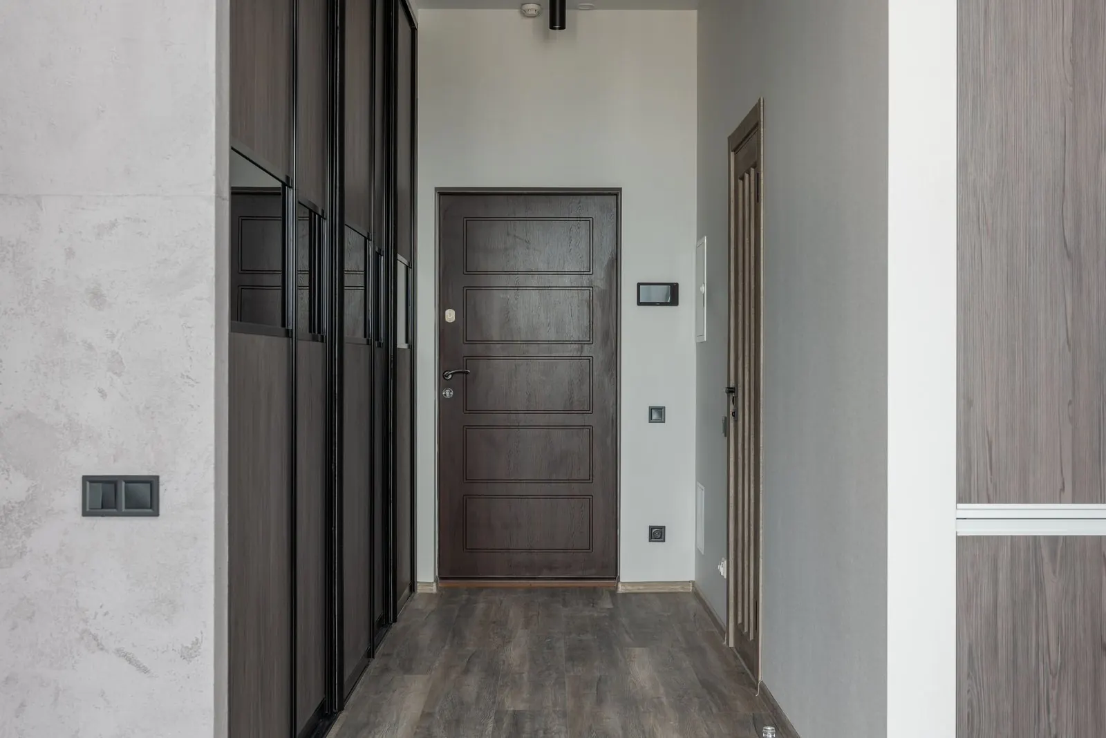 Narrow entrance hallway with grey wood-look vinyl planks