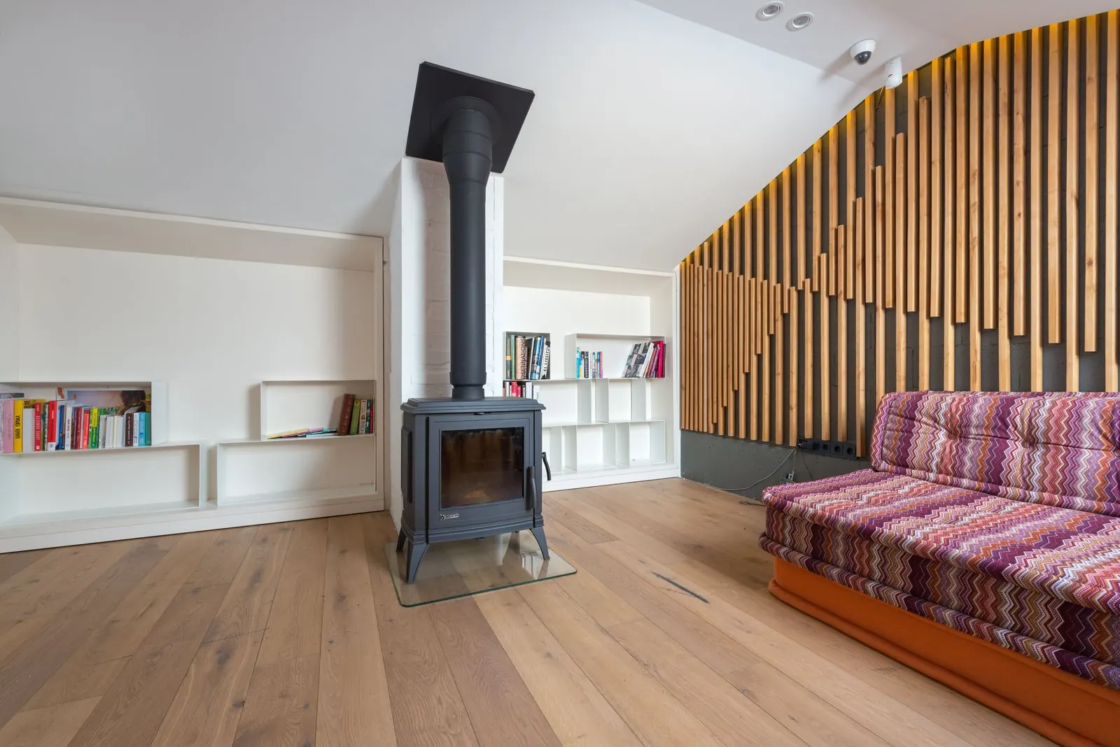 Living room with a wood stove and wide natural oak plank floor