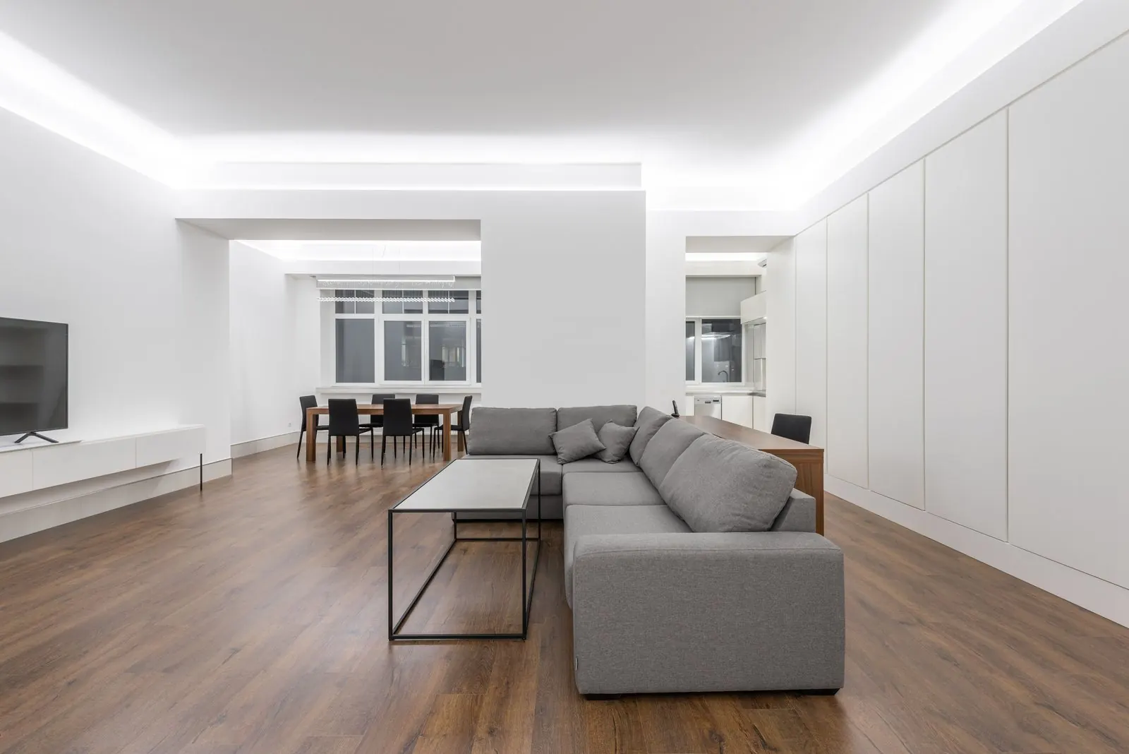 Open living room with brown wood-look laminate planks laid in straight rows